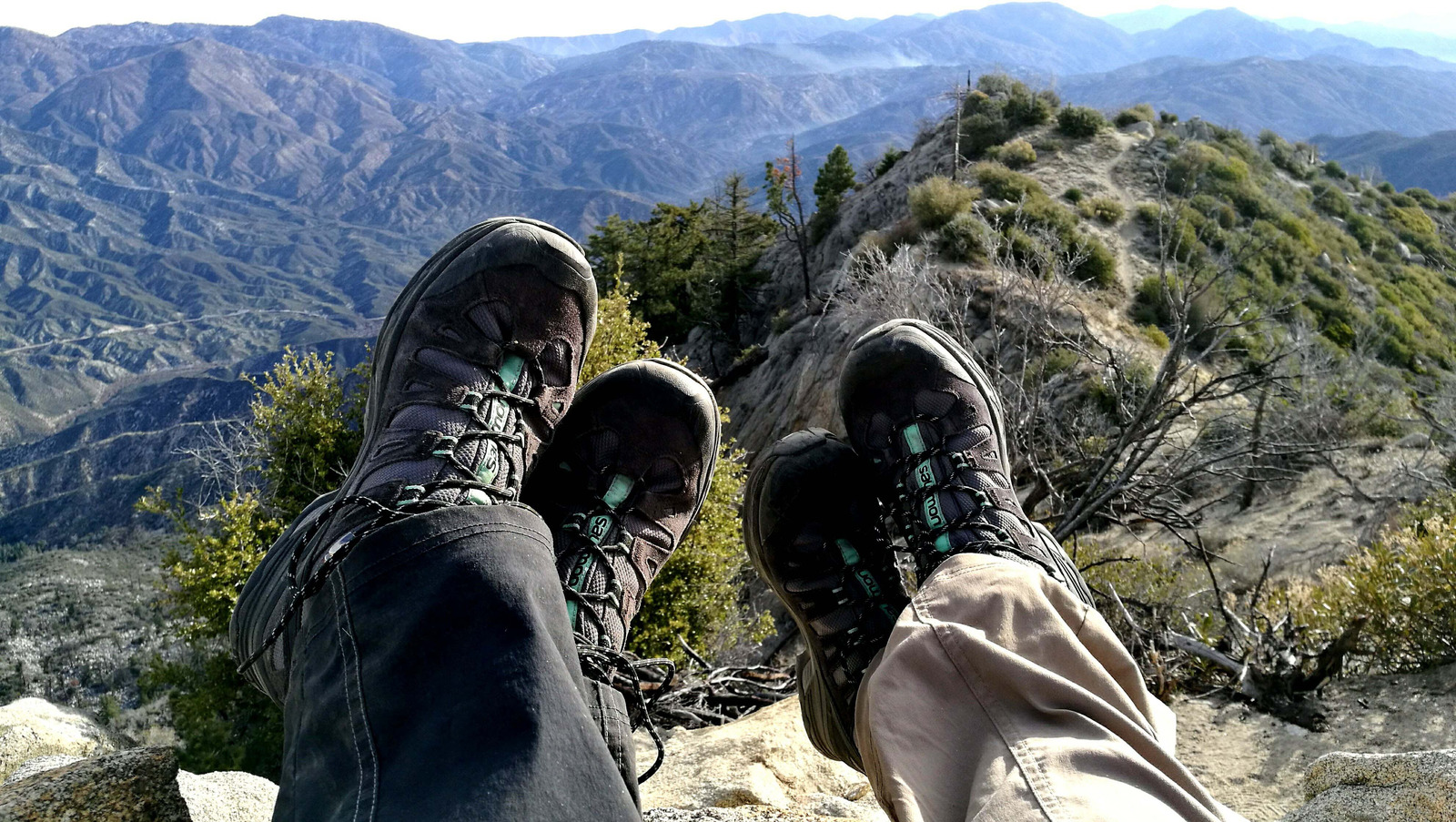 two people hiking in the mountains stopping to take a rest